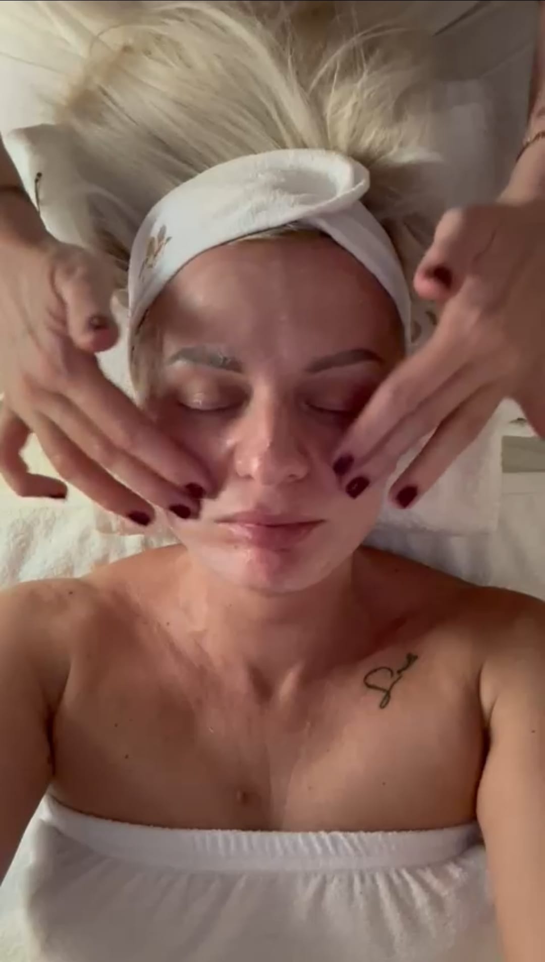 Bliski kadar lica plave žene dok kosmetičarka priprema kožu antiseptikom pre tretmana Dermapen microneedlinga.